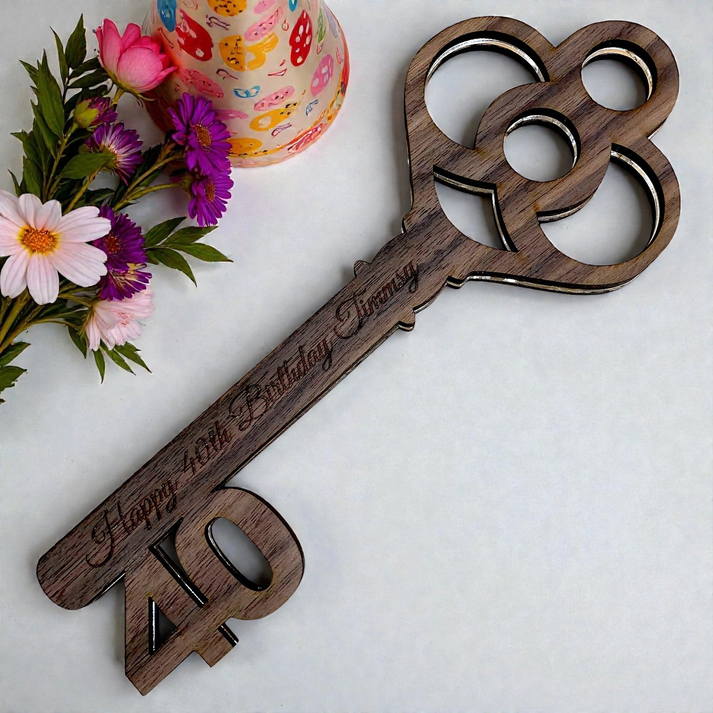 Custom wooden key cutout, laser-engraved with "Happy 40th Birthday Timmy" and a large "40" on the blade.