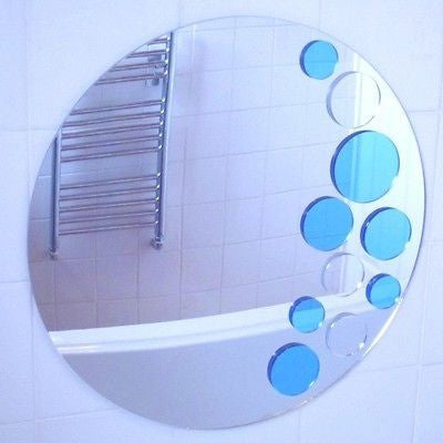 Round mirror featuring blue and silver circular bubble accents along the right side, mounted on a tiled wall.