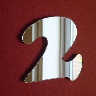 Reflective acrylic number 2 mirror shaped in a playful font, mounted on a solid dark red wall.