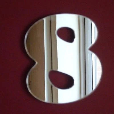 A silver mirror in the shape of the number 8 against a dark red background.
