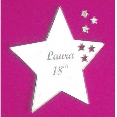 Personalised star-shaped acrylic mirror engraved with "Laura 18th" and decorative stars against a pink background.