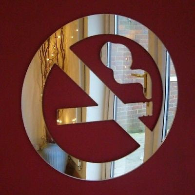 Circular mirror shaped like a no smoking sign, mounted on a red wall.