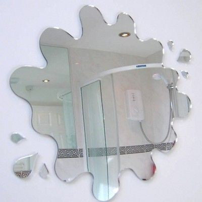 Puddle and six splatters mirror shaped like water splashes, hanging on a white wall.