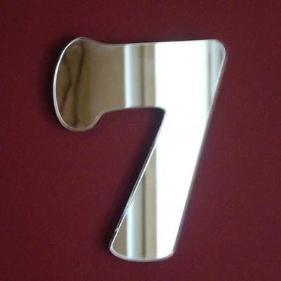 Number 7 shaped decorative mirror against a solid maroon background.