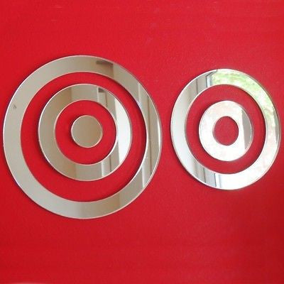 Two silver circular infinity mirrors with concentric ring designs on a red background.