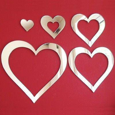 Five heart-shaped silver mirrors arranged on a red background.