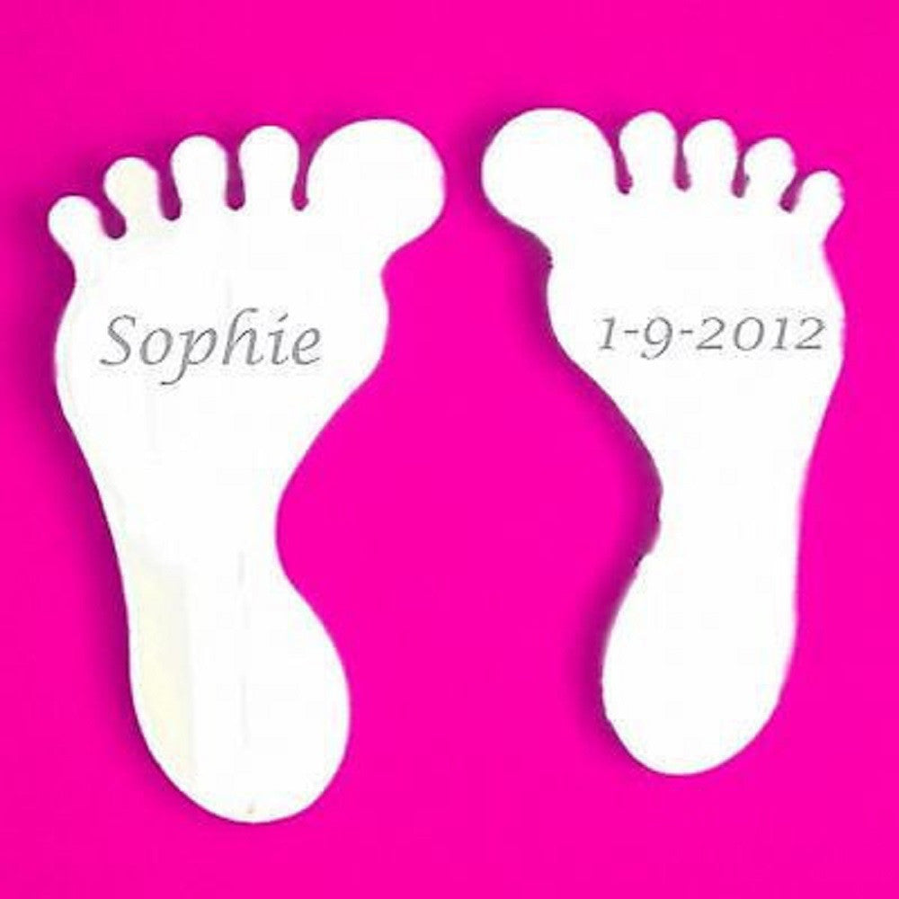 Pair of reflective foot-shaped mirrors engraved with the name Sophie and date 1-9-2012 against a pink background.
