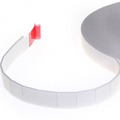 A roll of double-sided white foam adhesive tape with a red backing liner.