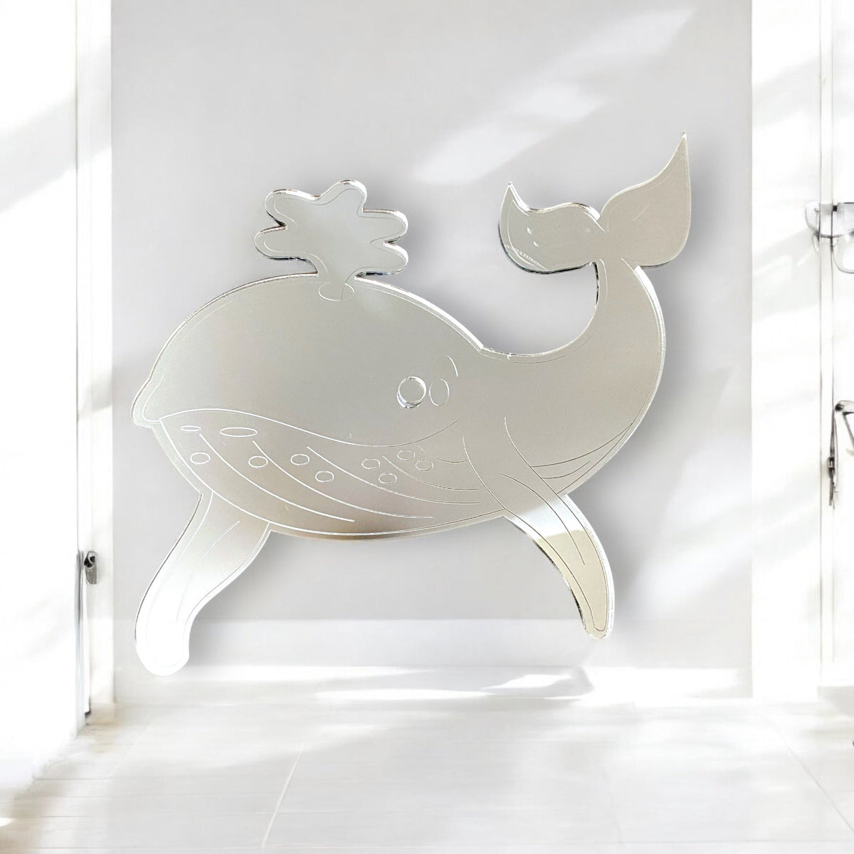 Etched whale-shaped mirror mounted on a white wall.