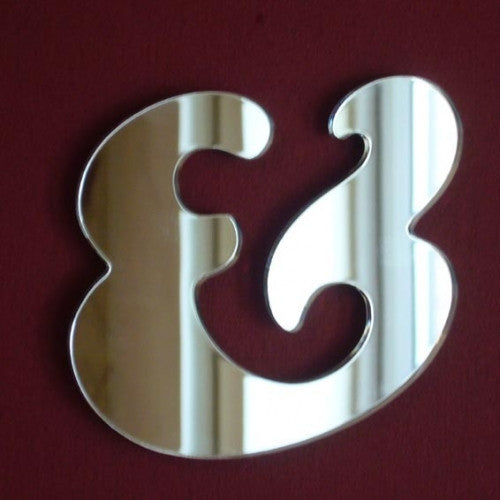 A reflective, curved ampersand-shaped wall mirror against a dark background.