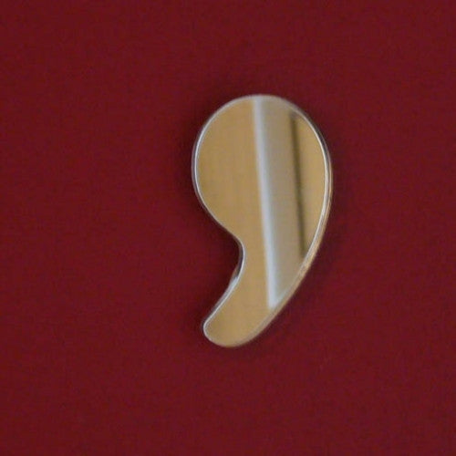 A comma-shaped mirror mounted on a solid red wall.