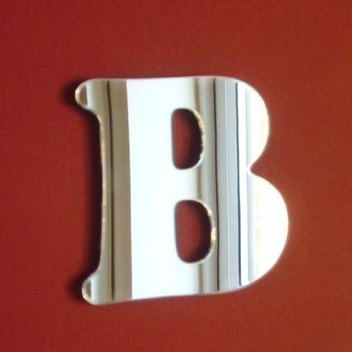 A silver letter B mirror against a solid dark red background.
