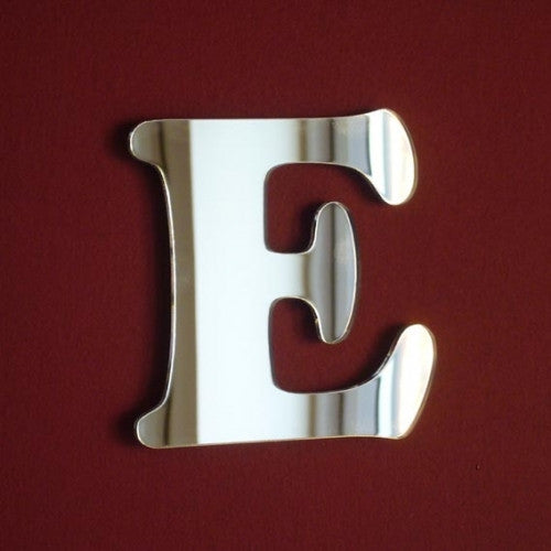 A silver reflective mirror in the shape of a funky letter E on a dark red background.
