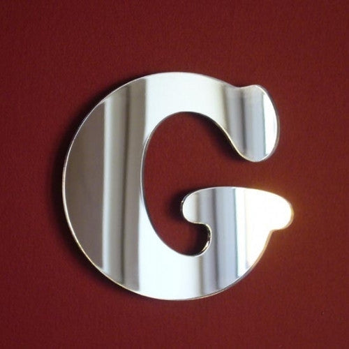 Funky letter G shaped mirror in silver against a red background.