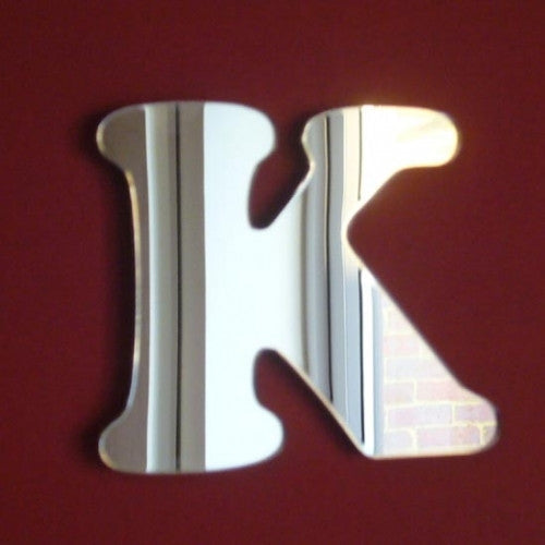 A reflective, funky letter K mirror with rounded serifs on a dark red background.