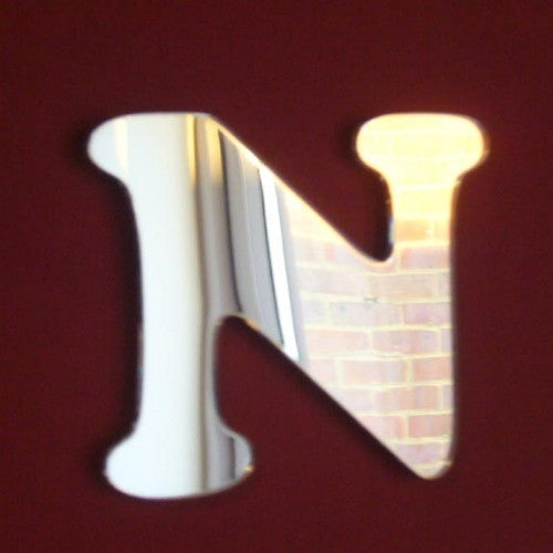 Funky letter N mirror in a silver reflective finish against a dark background.