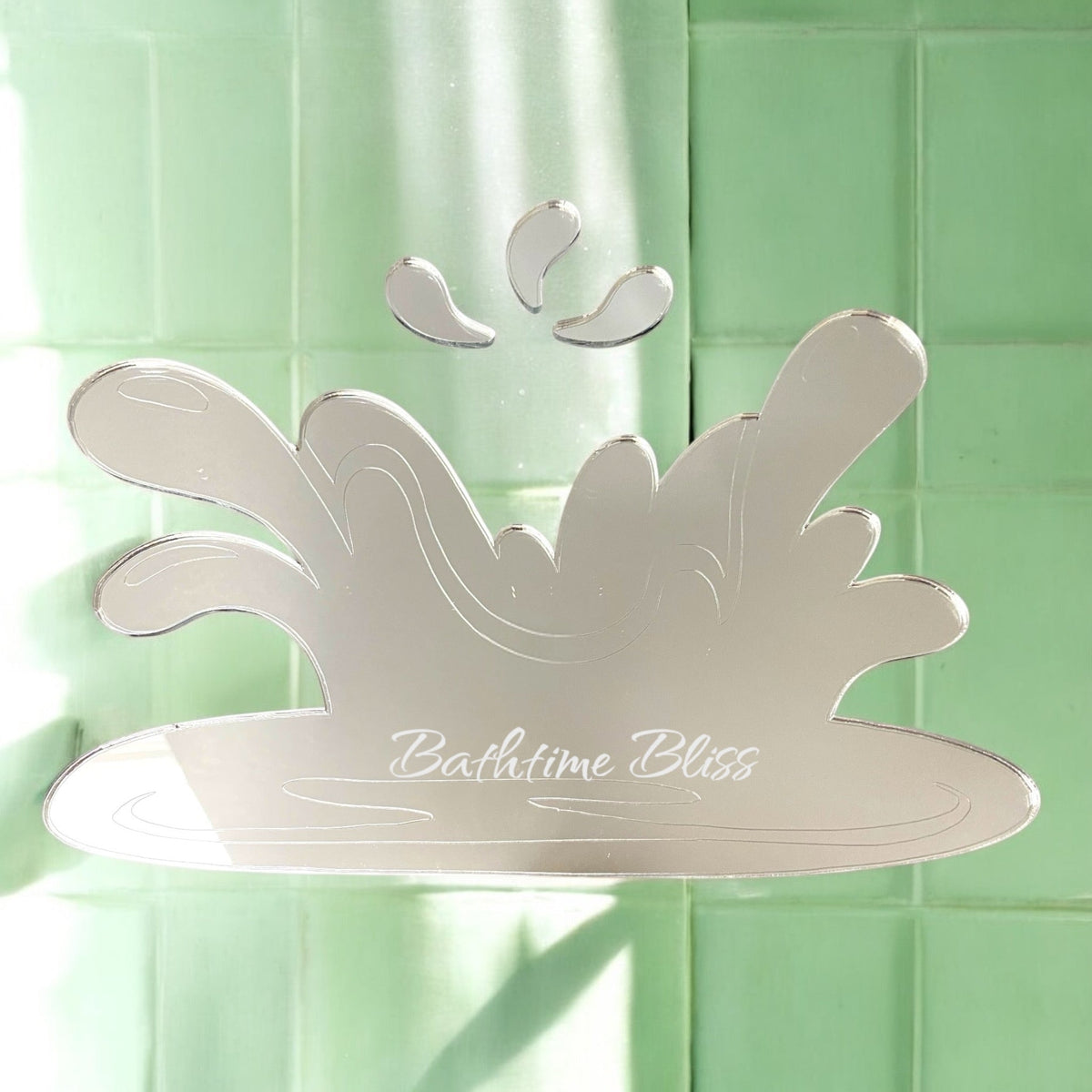 Etched water splash mirror with "Bathtime Bliss" text on a green tiled wall.
