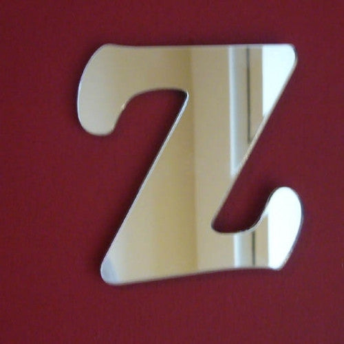 A reflective, stylized letter Z mirror mounted on a red wall.