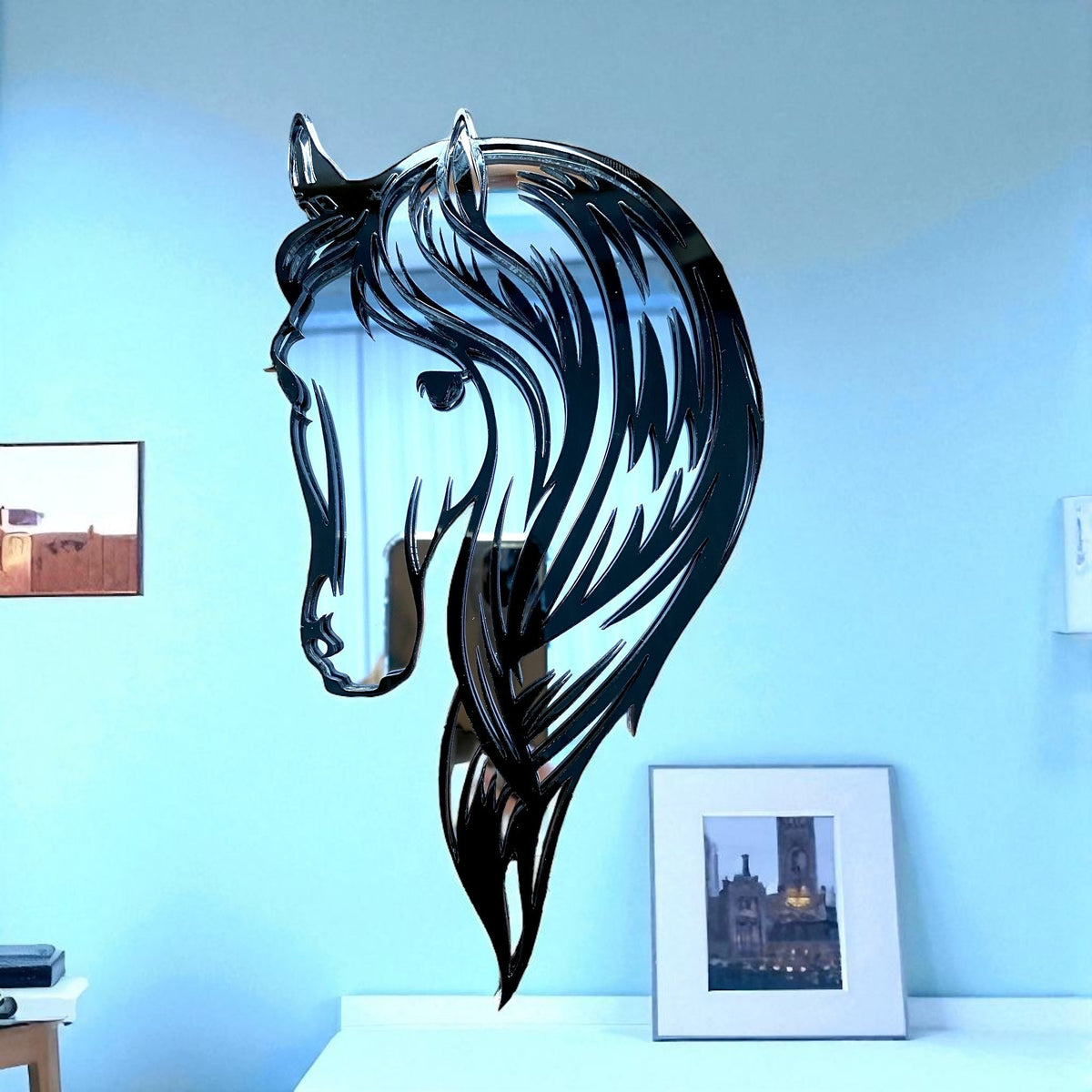 Silver horse head garden mirror shaped like a stylized profile with flowing mane, mounted on a blue wall.