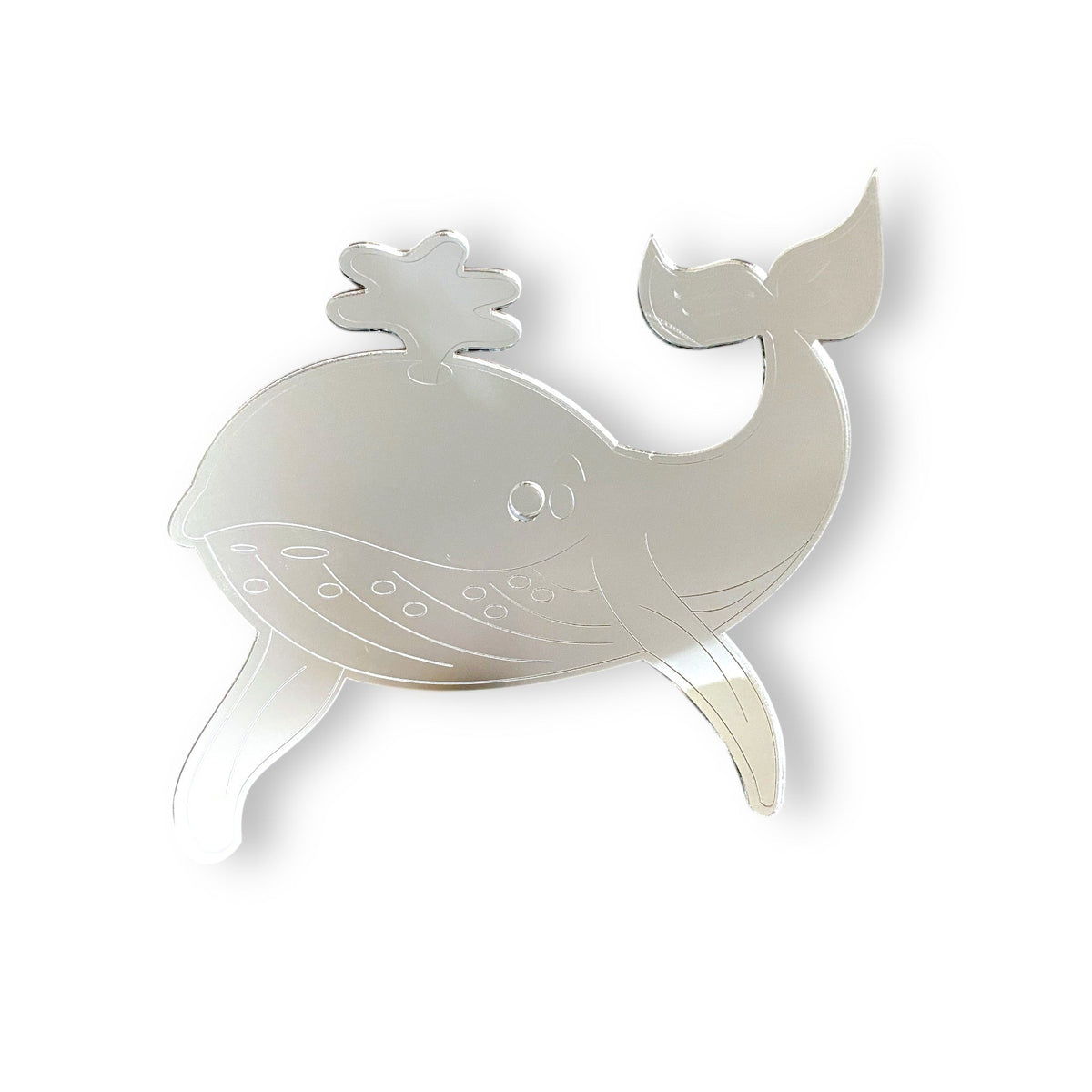 An etched silver whale-shaped mirror with water spout and belly details.
