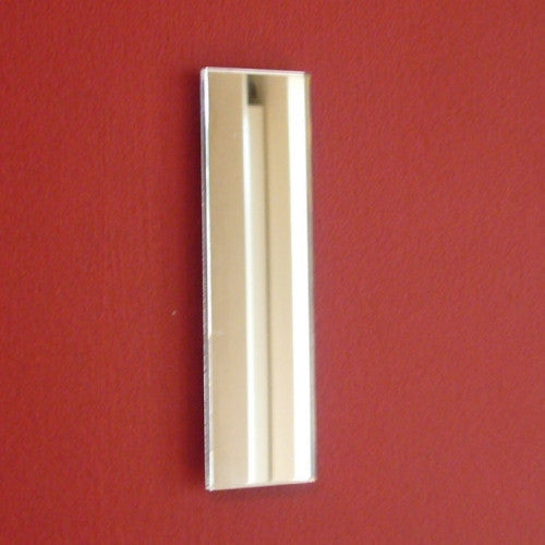 A contemporary rectangular mirror shaped like the letter I mounted on a red wall.