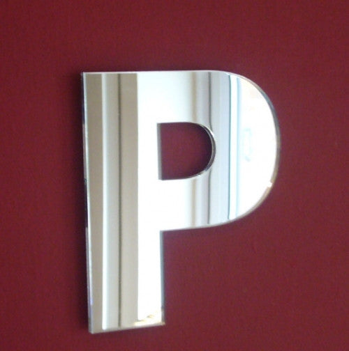 Contemporary letter P wall mirror, featuring a sleek, reflective silver finish mounted on a deep red wall.