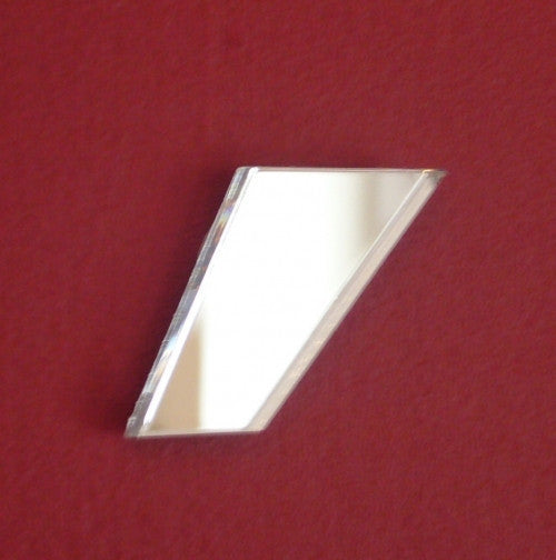 A contemporary comma-shaped glass mirror on a red textured background.