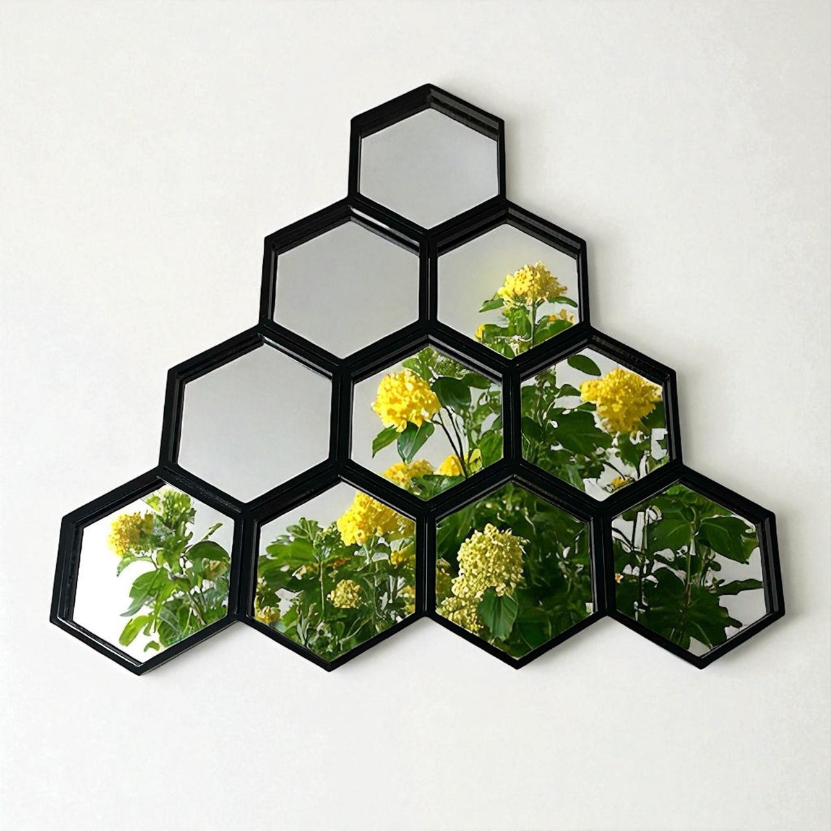 Cluster of 7 black-framed hexagonal mirrors forming a honeycomb shape, reflecting green plants with yellow flowers.