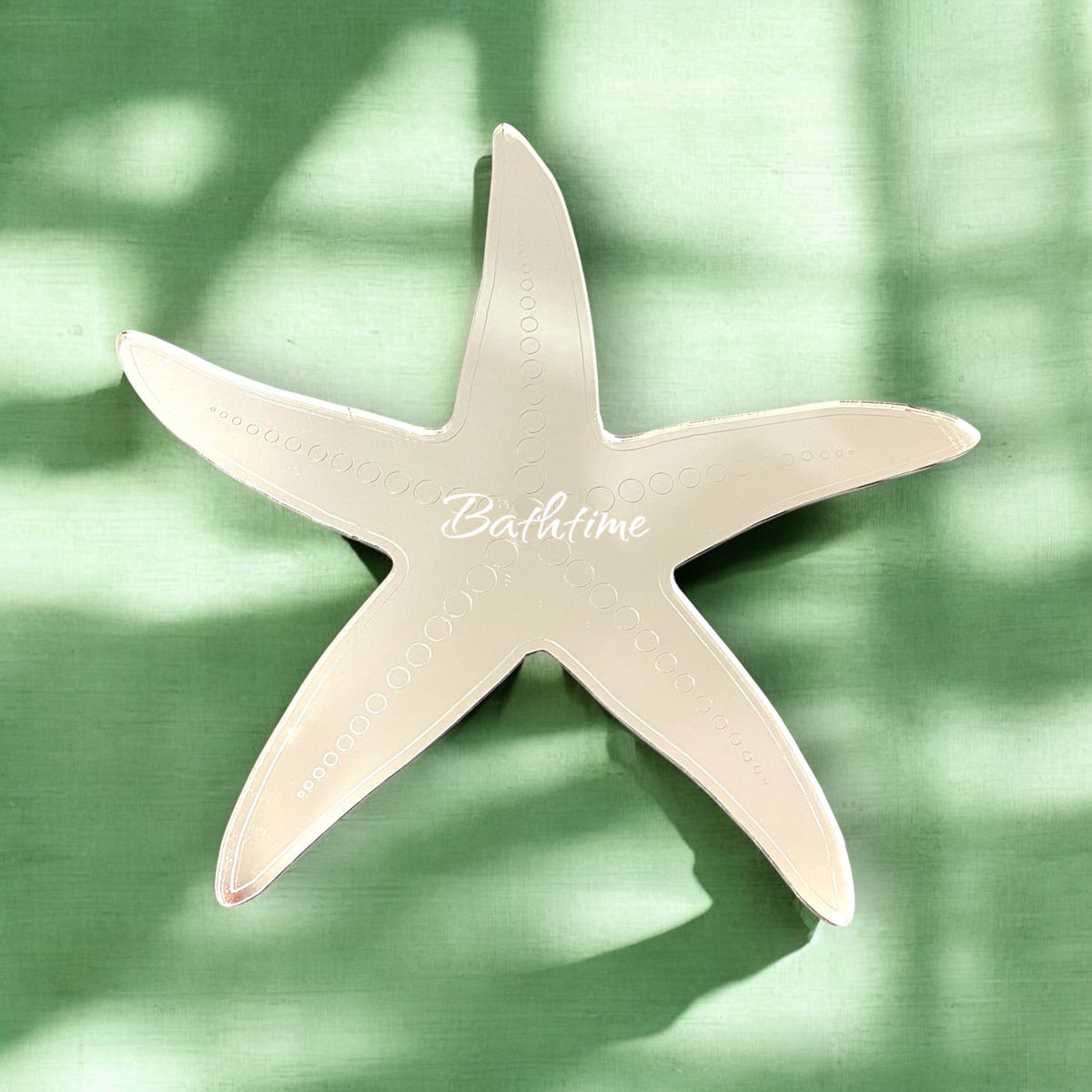 A starfish-shaped mirror with etched circles along its arms and the text "Bathtime" in the center.