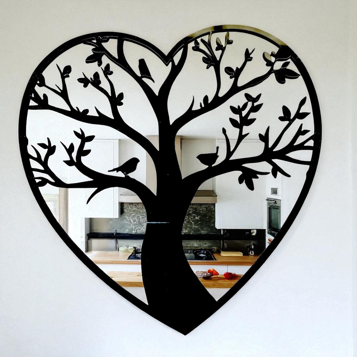 Heart-shaped wall mirror with a black Tree of Life silhouette, featuring branches, leaves, and birds.