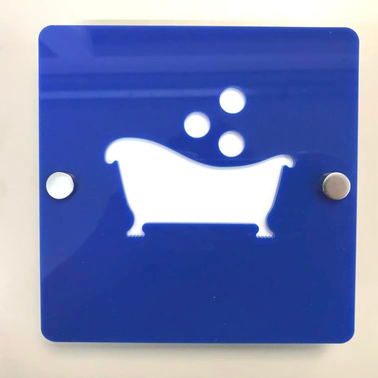 Square blue acrylic sign with white cutout of a bathtub and bubbles, secured with silver standoffs.