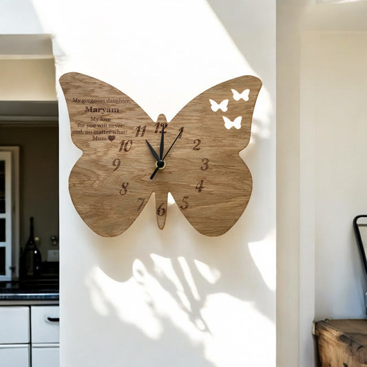 Wooden butterfly-shaped wall clock with black hands, engraved numbers, and personalized text for Maryam.