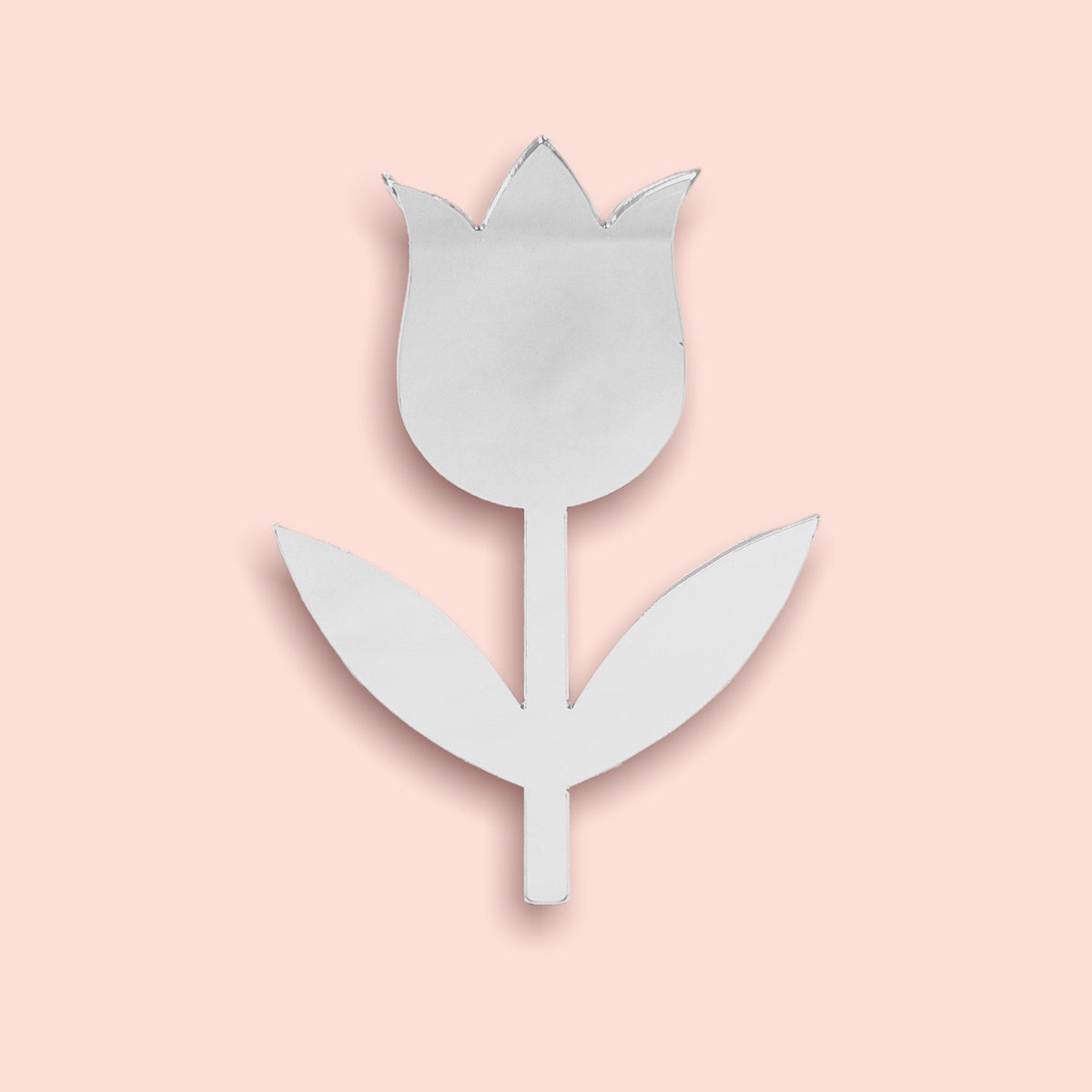 Silver tulip-shaped mirror with a stem and two leaves on a pale pink background.