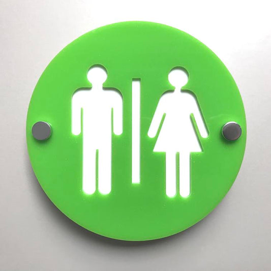 Round green floating male and female toilet sign with silver standoffs on a white wall.