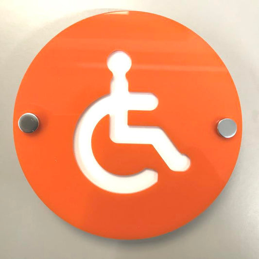 Round orange floating disabled toilet sign with a white wheelchair symbol, mounted with silver standoffs.