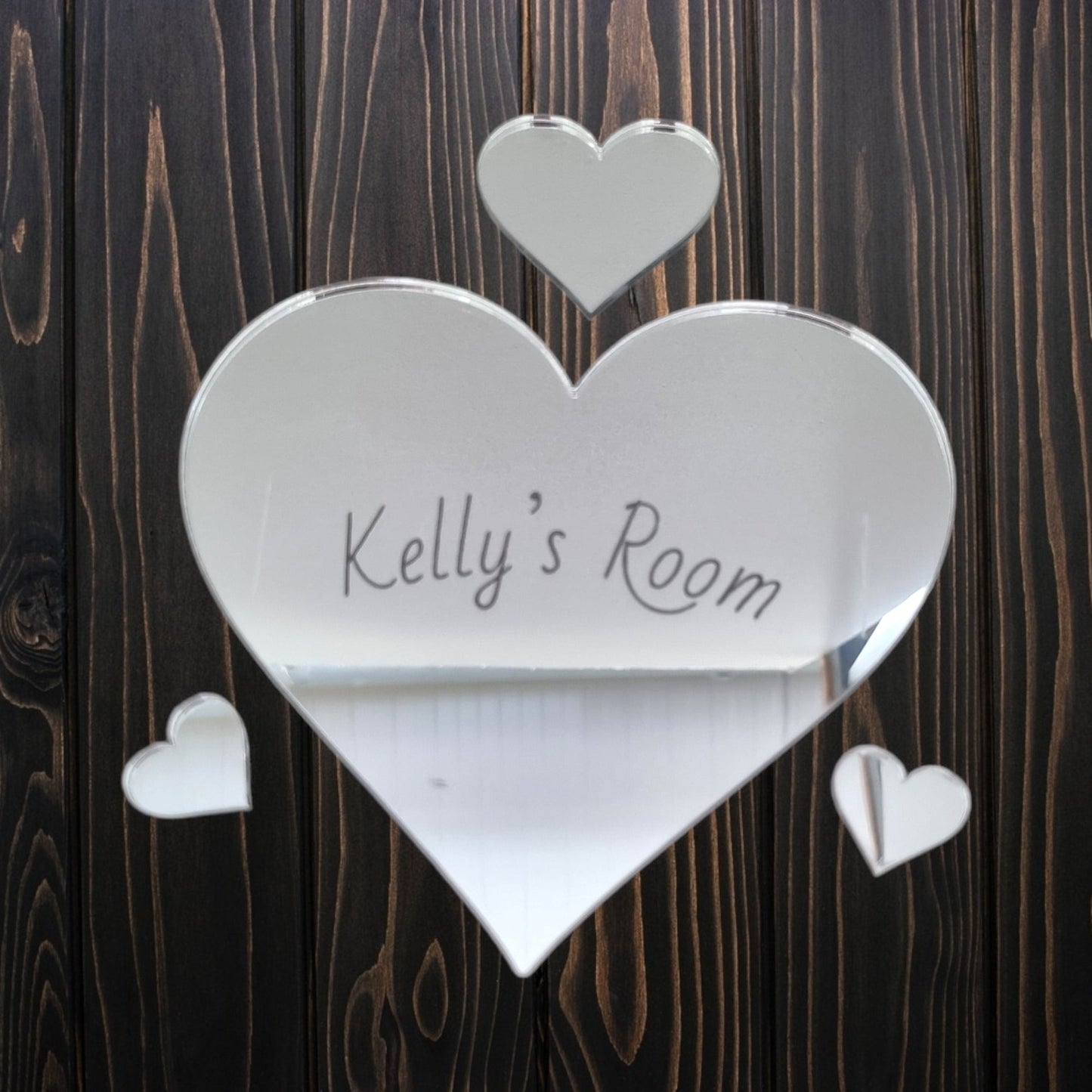 Personalised heart-shaped mirrored door sign with "Kelly's Room" and three smaller hearts on wood.