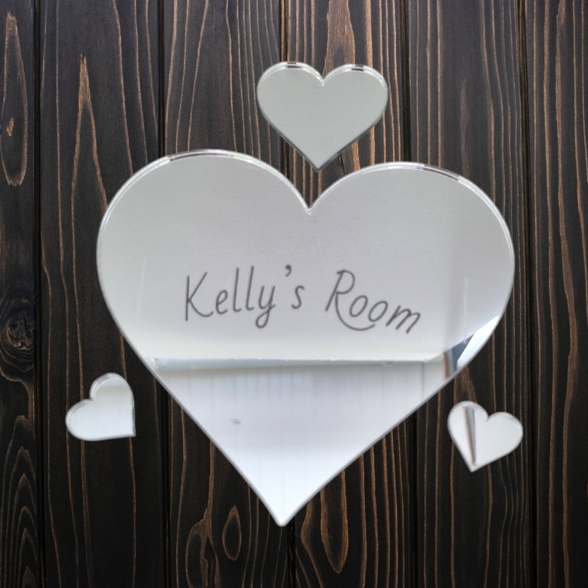 Personalised heart-shaped mirrored door sign with "Kelly's Room" and three smaller hearts on wood.
