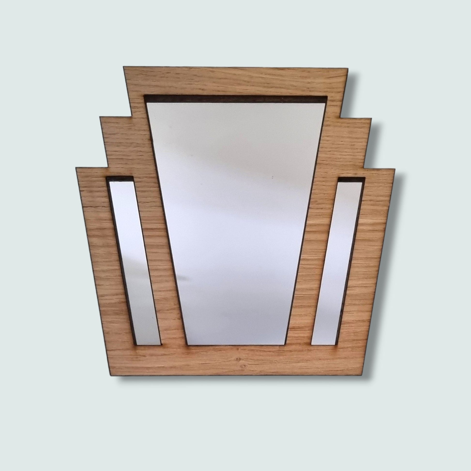 Art Deco style mirror with a stepped light brown wood frame enclosing three vertical mirrored panels.