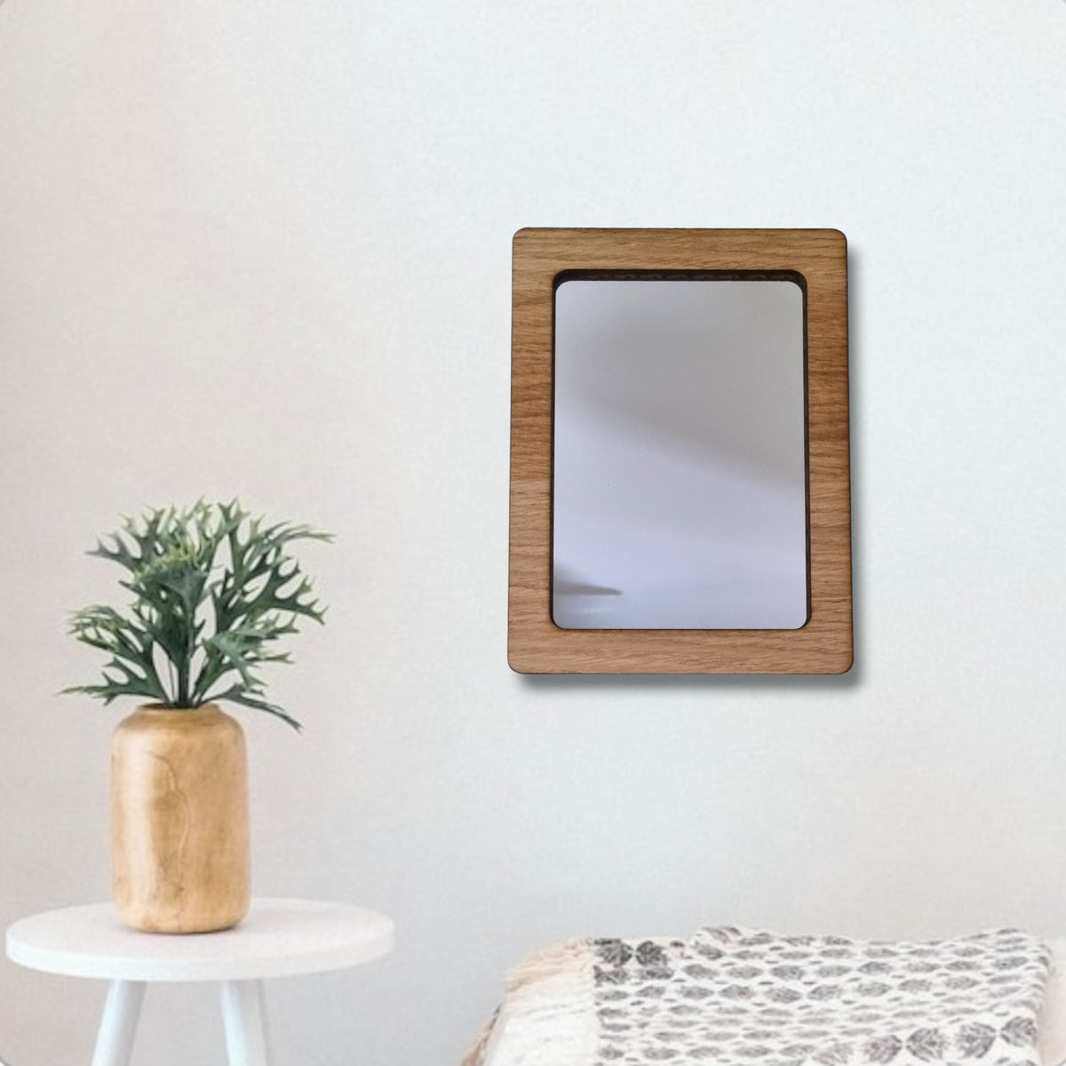 Rectangle wood framed mirror hanging on a white wall.