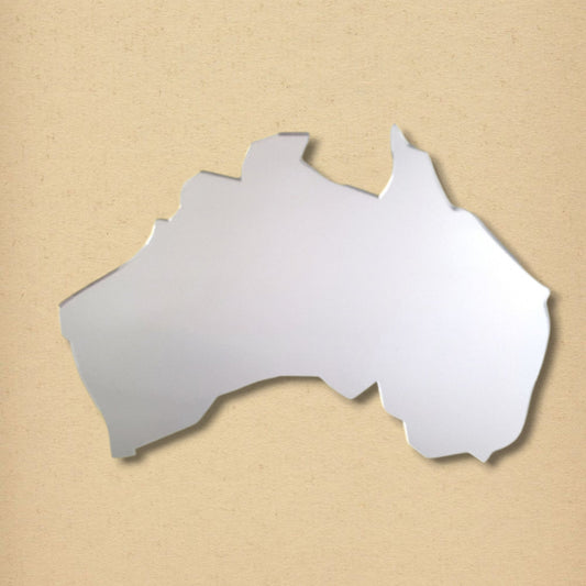 Australia map-shaped silver mirror against a plain beige textured background.