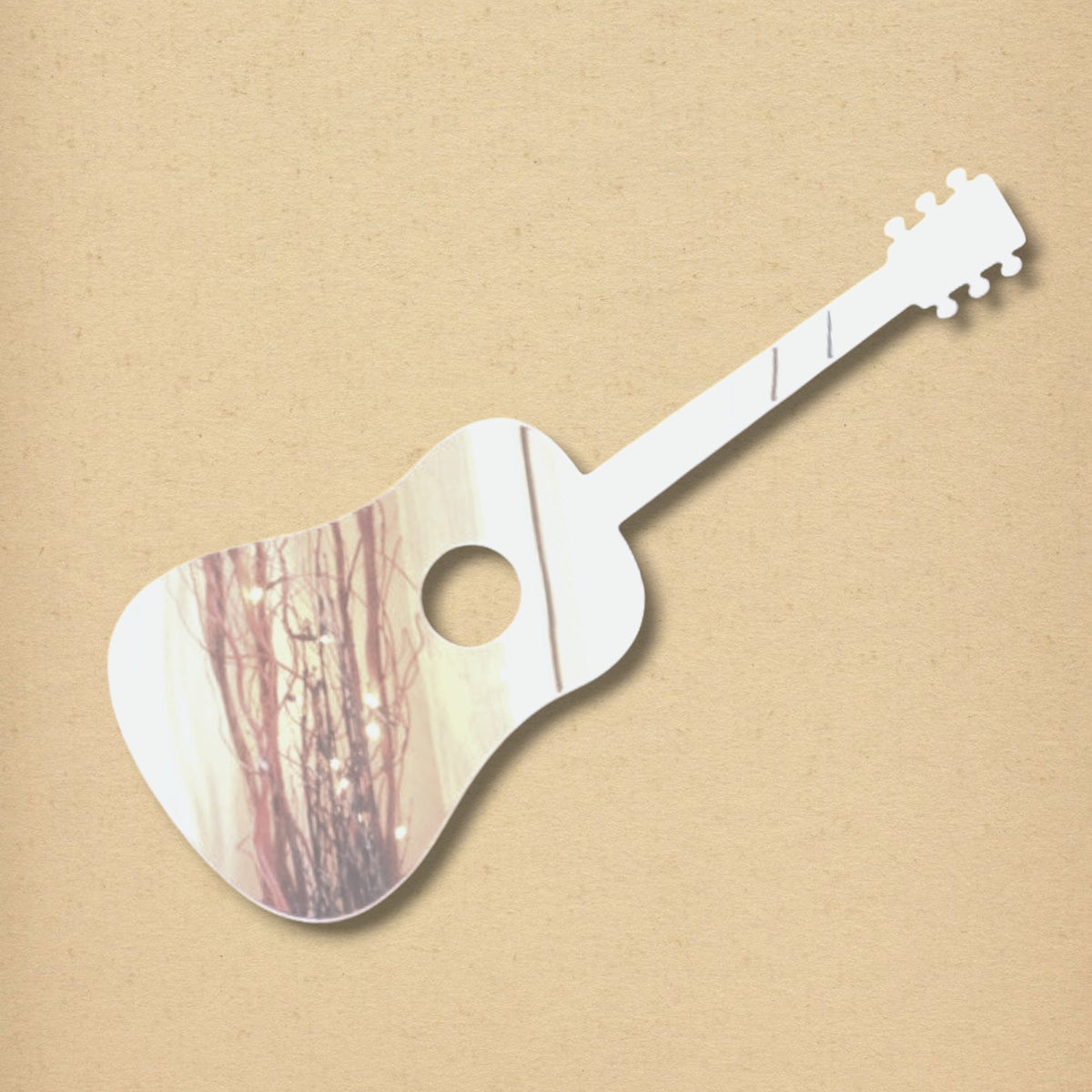 Acoustic guitar-shaped mirror with a reflective surface showing a room interior, on a tan textured background.