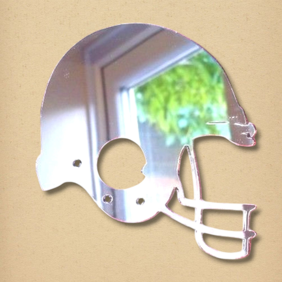 Reflective American football helmet shaped mirror with a faceguard cutout, shown against a tan background.