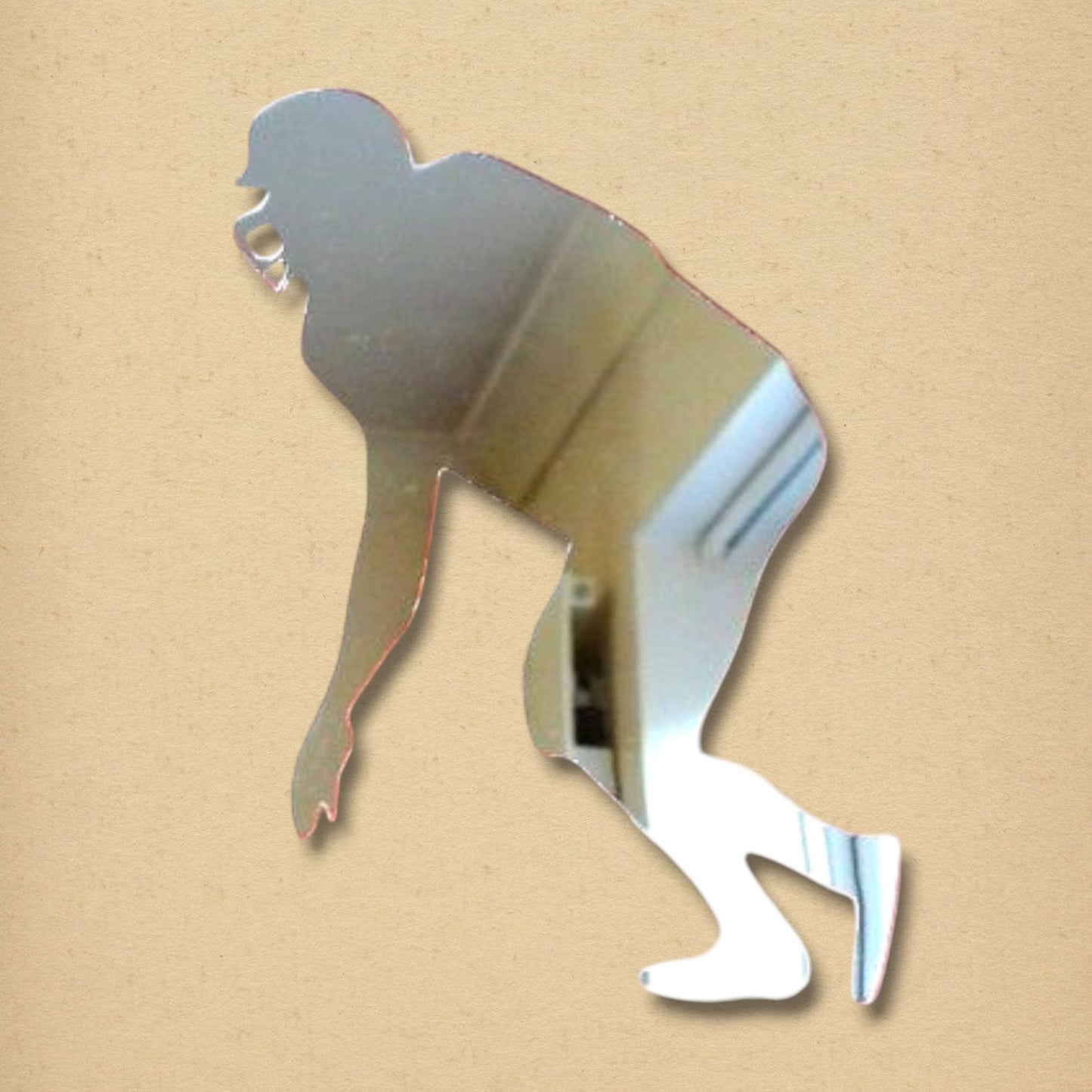 American footballer-shaped mirror on a textured beige background.