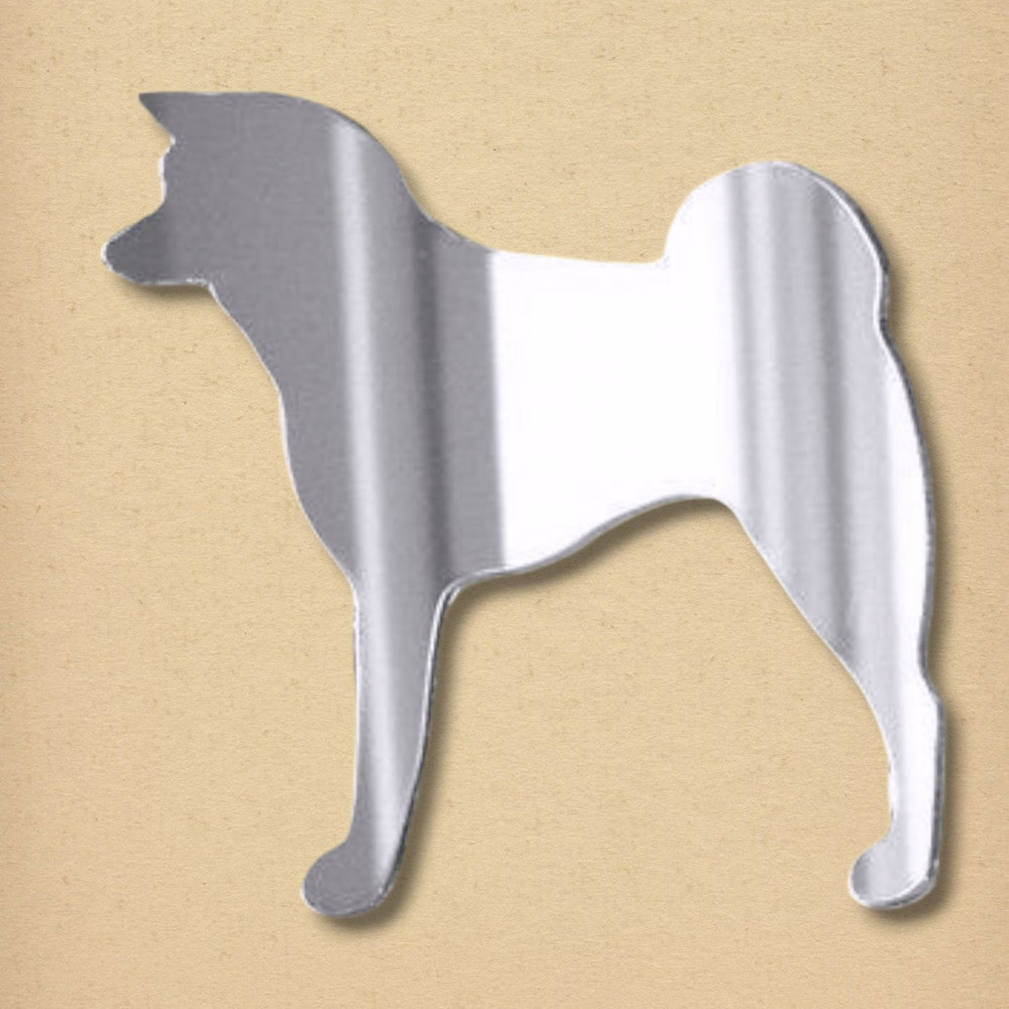 Silver-colored acrylic mirror shaped in the silhouette of a standing Japanese Akita dog with a curled tail.