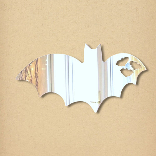 Bat-shaped mirror with three small cutouts resembling bats flying away on the right wing.