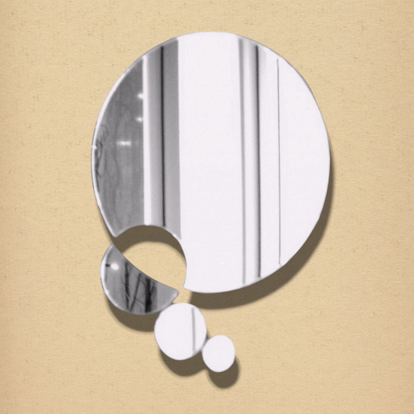 A silver circular mirror with abstract connected smaller circles against a textured beige background.