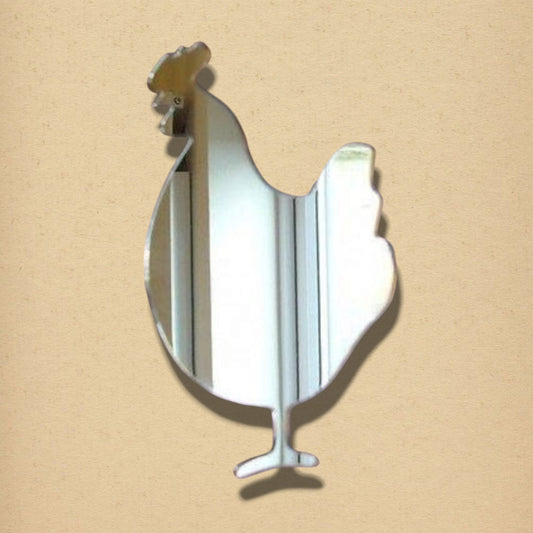 A cockerel-shaped mirror made of reflective glass on a plain beige background.