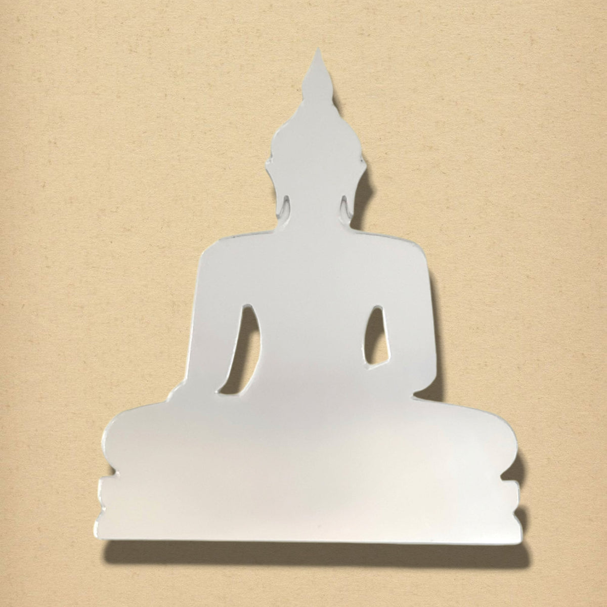 Buddha-shaped silver mirror on a textured tan background.