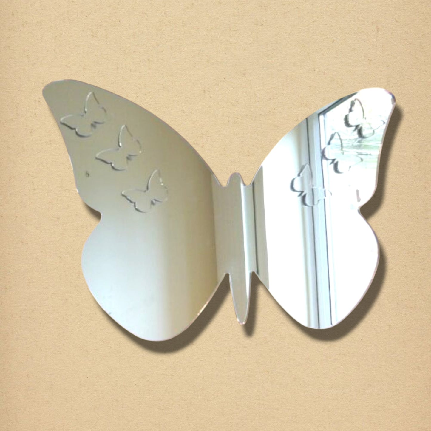A butterfly-shaped mirror featuring small etched butterfly designs on its wings.