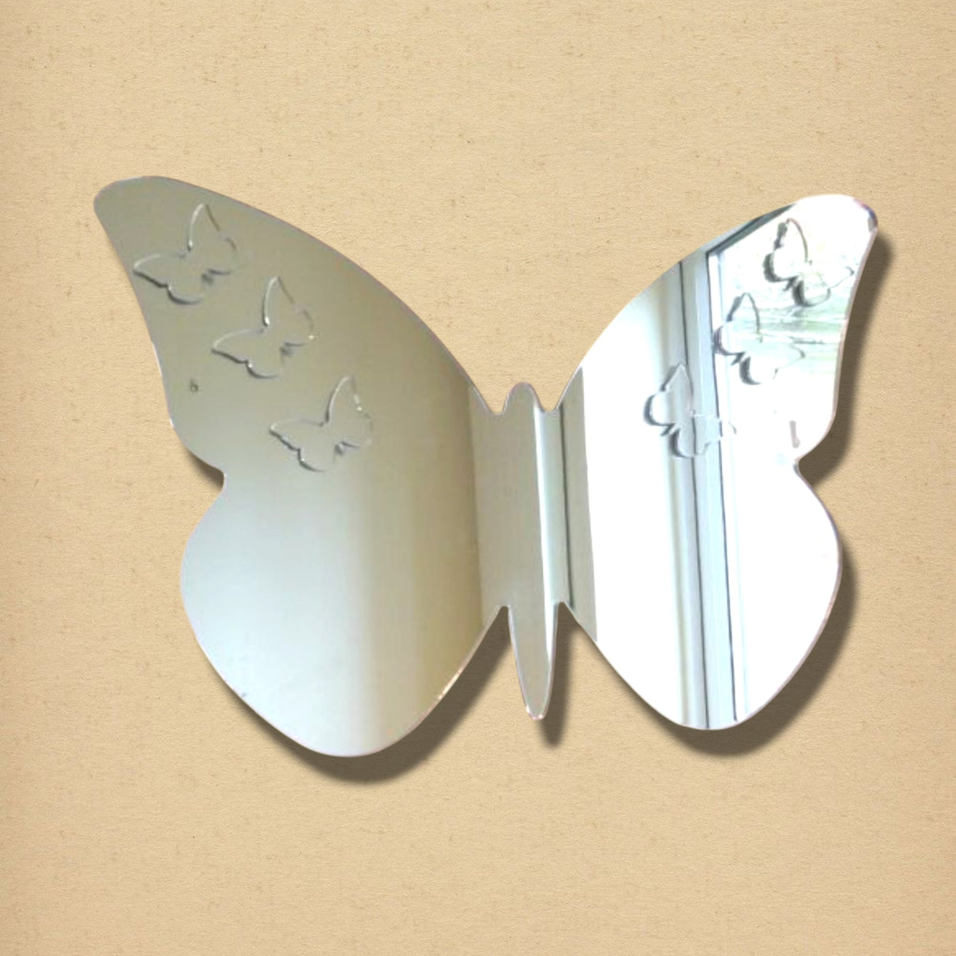 A butterfly-shaped mirror featuring small etched butterfly designs on its wings.